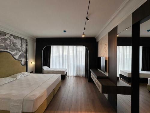 a bedroom with a large bed and a large window at Premium Beach Hotel in Golem