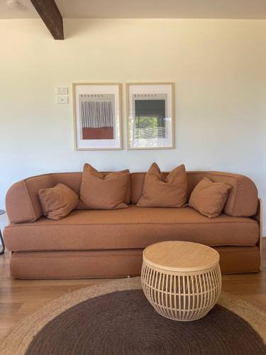 a living room with a brown couch and a coffee table at Archy's on the Lake in Burrill Lake