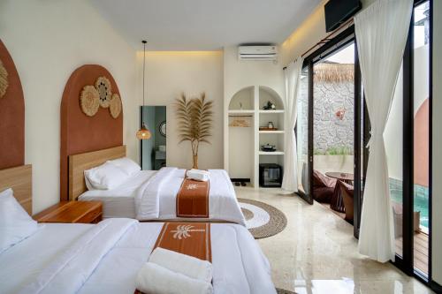 a hotel room with two beds and a balcony at Palm Villa Prawirotaman in Timuran