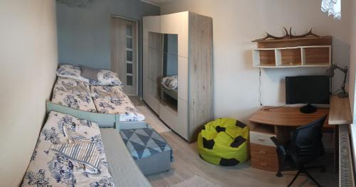 a bedroom with two beds and a desk and a computer at Chata košaríska in Oščadnica