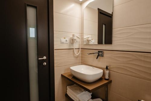a bathroom with a white sink and a mirror at Atri's Boutique in Aiud