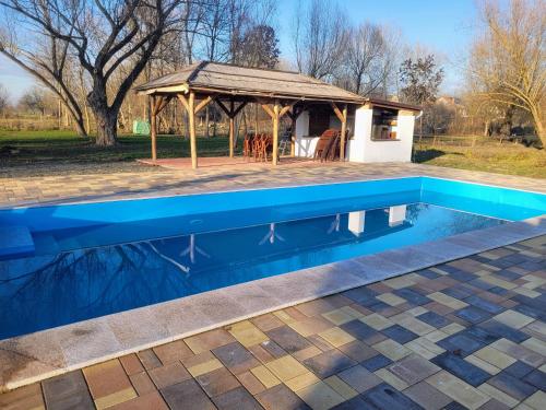 a swimming pool in front of a gazebo at Végvári Vendégház in Magyarbóly