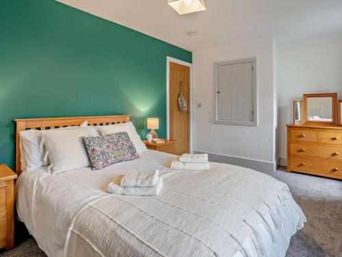 a bedroom with a large bed with a blue wall at 3 Bed in Brecon oc-96240 in Llandefaelogfâch