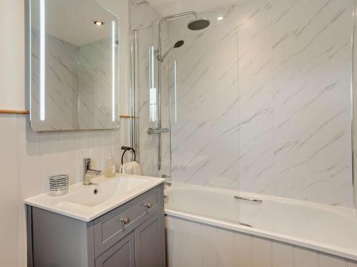 a white bathroom with a sink and a shower at 3 Bed in Brecon oc-96240 in Llandefaelogfâch