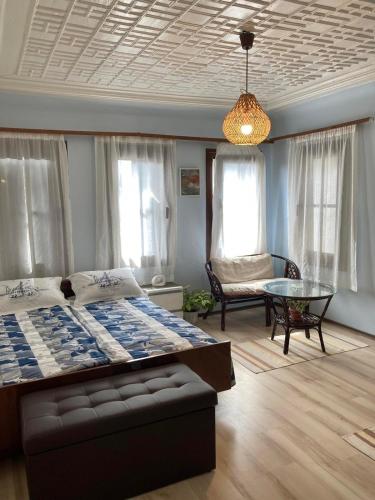 a bedroom with a bed and a table and windows at Historic House in the Heart of Old Town Sozopol in Sozopol