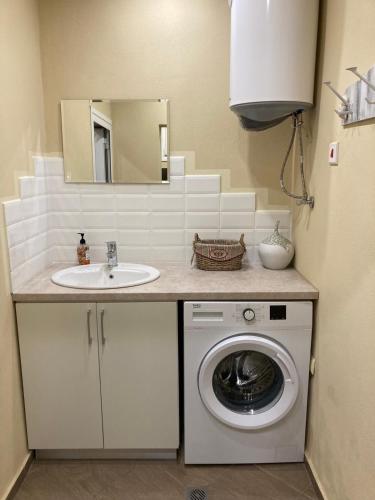 a bathroom with a washing machine and a sink at Historic House in the Heart of Old Town Sozopol in Sozopol