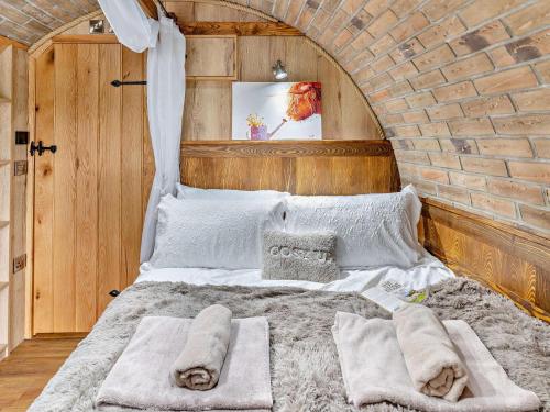 a bedroom with a large bed in a brick wall at 1 Bed in Brecon oc-95630 in Aber-Brân