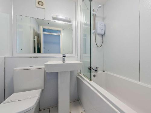 a bathroom with a sink and a toilet and a mirror at 2 Bed in Woolacombe oc-bkers in Woolacombe