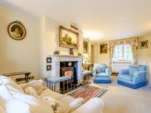 a living room with a fireplace and blue chairs at 3 Bed in Presteigne oc-78336 in Evenjobb