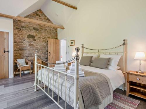 a bedroom with a bed and a stone wall at 1 Bed in Craven Arms oc-54928 in Clungunford