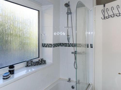 a white bathroom with a shower and a tub at 2 Bed in Neath oc-bn247 in Crynant