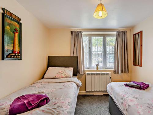a bedroom with two beds and a window at 2 Bed in Bideford oc-40281 in Northam
