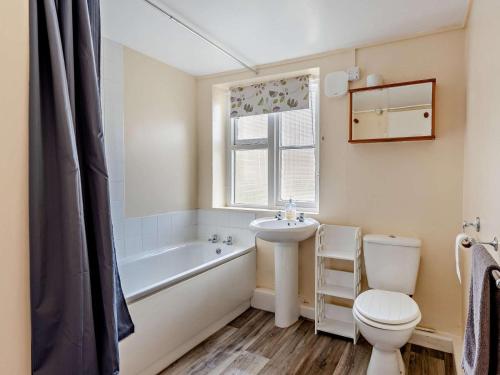 a bathroom with a toilet and a tub and a sink at 2 Bed in Bideford oc-40281 in Northam