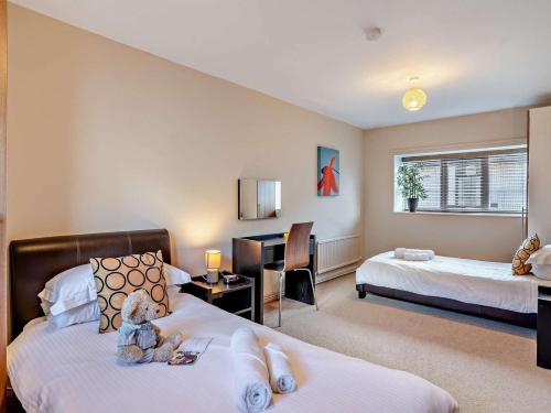 a hotel room with two beds and a teddy bear on the bed at 3 Bed in Brecon oc-bn304 in Brecon