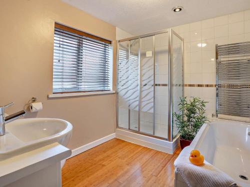 a bathroom with a tub and a sink and a shower at 3 Bed in Brecon oc-bn304 in Brecon