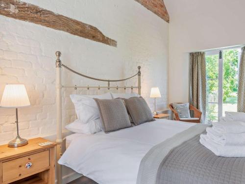 a bedroom with a large white bed and a window at 1 Bed in Craven Arms oc-54926 in Clungunford