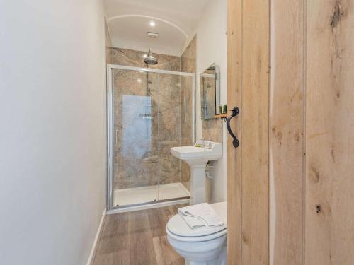 a bathroom with a toilet and a glass shower at 1 Bed in Craven Arms oc-54926 in Clungunford