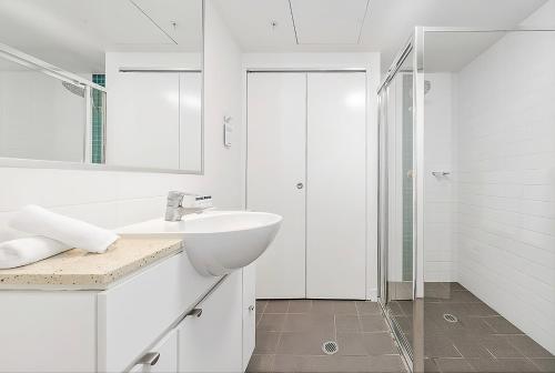 a white bathroom with a sink and a shower at CITY Centre With Awesome Views! in Brisbane