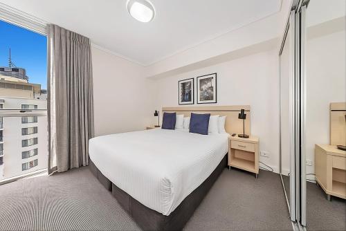 a white bedroom with a large bed and a window at CITY Centre With Awesome Views! in Brisbane