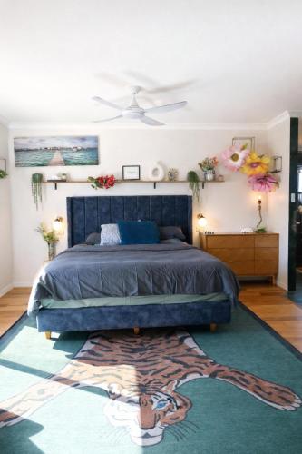 a bedroom with a blue bed and a rug at Infinity Views in Utakarra