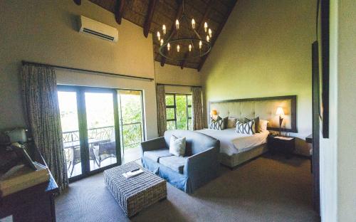 a large bedroom with a bed and a couch at The Blades in Pretoria