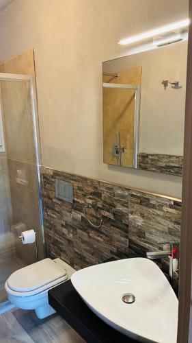 a bathroom with a sink and a toilet and a mirror at Case dei limoni sul mare in Capoliveri