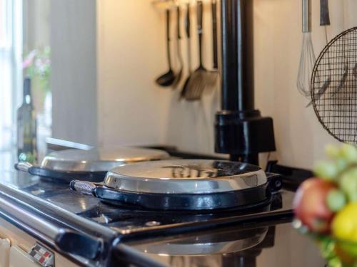 two pans sitting on top of a stove in a kitchen at 3 Bed in Ludlow oc-82889 in Ludlow