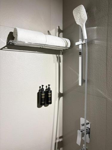 a shower in a bathroom with two bottles on a shelf at HYVE Siliguri in Siliguri