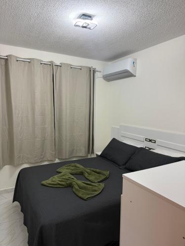 a bedroom with a bed with a green towel on it at Lisboa in João Pessoa