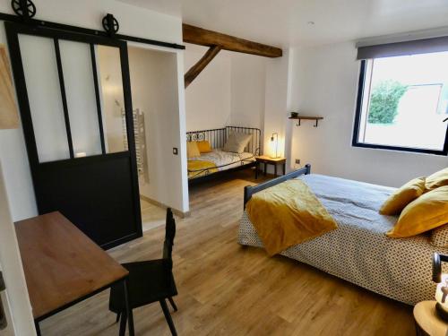 una camera da letto con un letto, una scrivania e un tavolo di Le Nichoir a Lion-en-Sullias