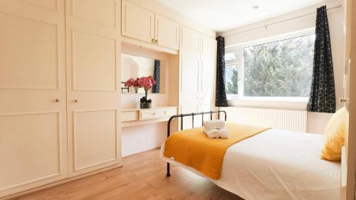 a white bedroom with a bed and a window at 4 Bedroom House with Garden & Parking in Ruislip in South Ruislip Station