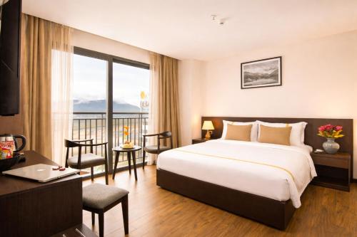 a hotel room with a bed and a table and chairs at Meriton Hotel Nha Trang in Nha Trang
