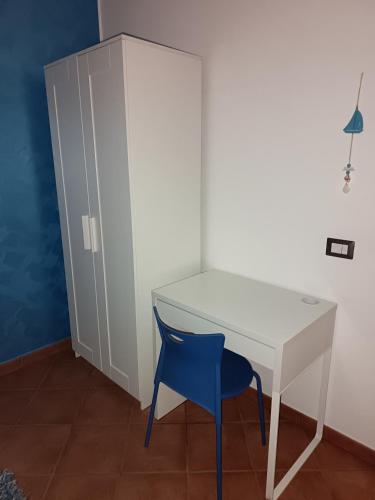 a white desk with a blue chair next to a cabinet at A due passi dal mare in Capo dʼOrlando