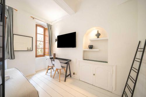 a bedroom with a bed and a desk with a tv at Cozy Studio A C 2P - Saint-Tropez in Saint-Tropez