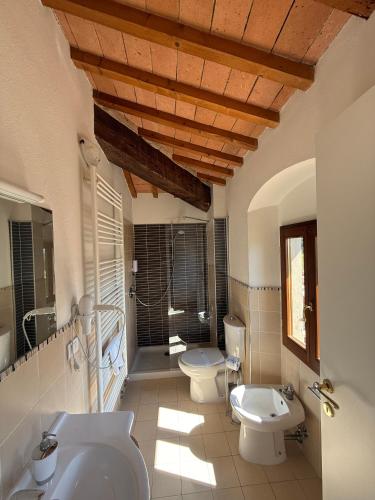 a bathroom with two toilets and a sink and a tub at Poggio Savelli in Scarperia