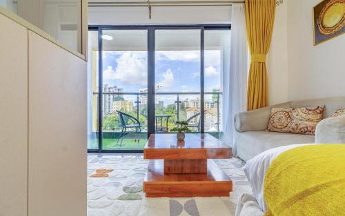 a living room with a couch and a table and a window at The Nestle & The Cradle - Kileleshwa in Nairobi