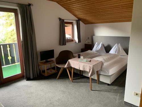 a bedroom with a bed and a table and a window at Garni Franz Leiter in Lagundo