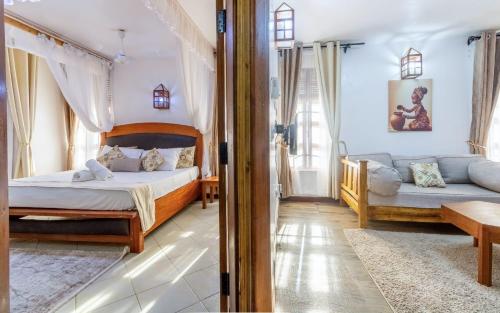 a bedroom with two beds and a couch at Savannah Bstan Luxury Apartment in Diani Beach