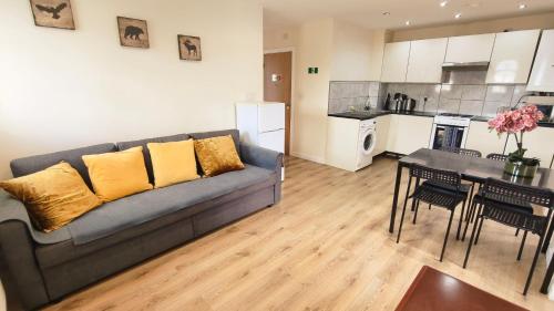 a living room with a couch and a table and a kitchen at Apple garden B-5 in London