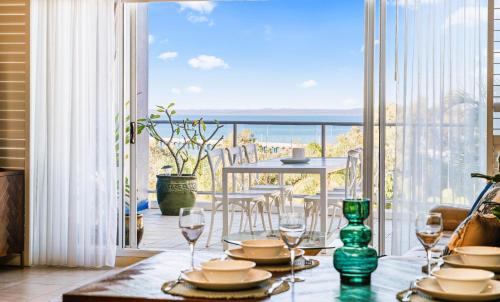 a dining room with a table and a view of the ocean at Oceanfront Spa Suite - Sub Penthouse in Urangan