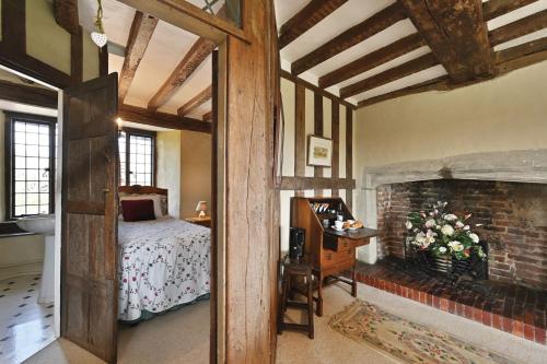 a bedroom with a bed and a fireplace at The William Penn At Wickham Manor in Winchelsea