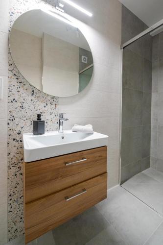 a bathroom with a sink and a mirror at Apartamenty Mazurska Strefa in Pisz