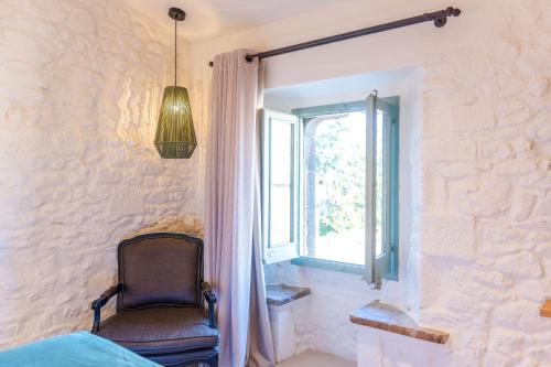 a chair sitting in a room with a window at Hotel Boutique Monells Summum in Monells