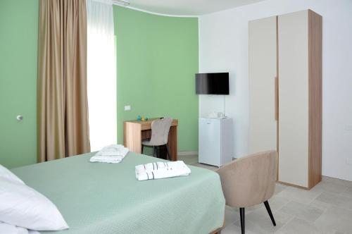 a bedroom with a bed with a table and a chair at Villa Luce Relax by Perle di Puglia in Villa Castelli