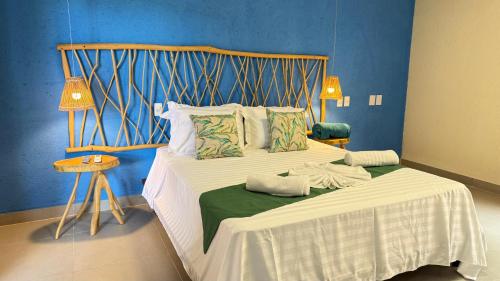 a bedroom with a bed with a wooden headboard at Pousada Verdes dos Corais in São Miguel dos Milagres