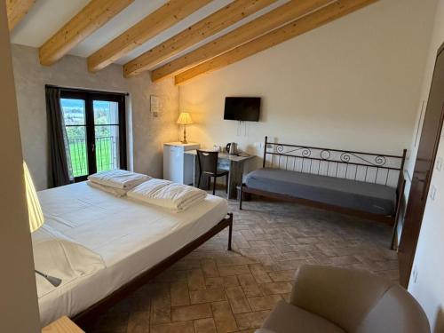 a bedroom with a bed and a desk and a chair at agriturismo2laghi in Ponti Sul Mincio