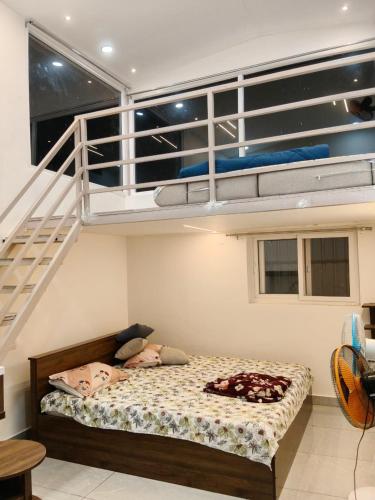 a bedroom with a bunk bed and a staircase at Cherish Farm Stay in Medchal