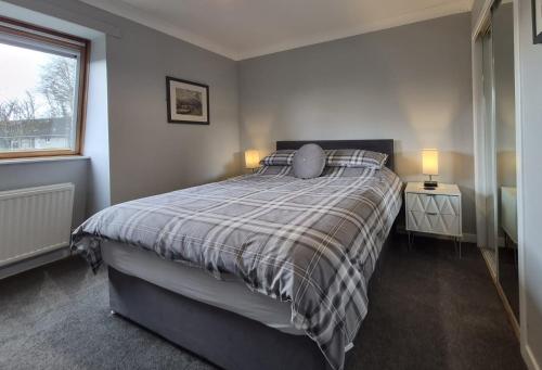a bedroom with a bed with two night stands and two lamps at Dunuaran in Oban