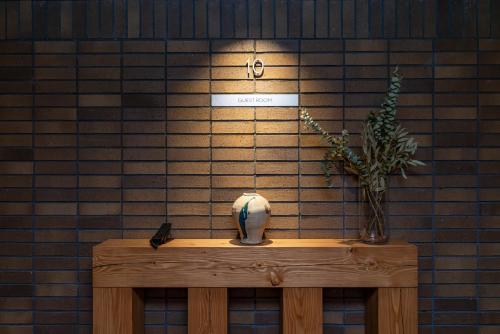 a table with a vase and a plant on a wall at Tokyu Stay Shibuya Ebisu in Tokyo