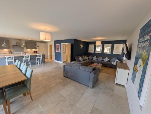 a living room and kitchen with a couch and a table at Green Ridge - detached seaside home in Chichester